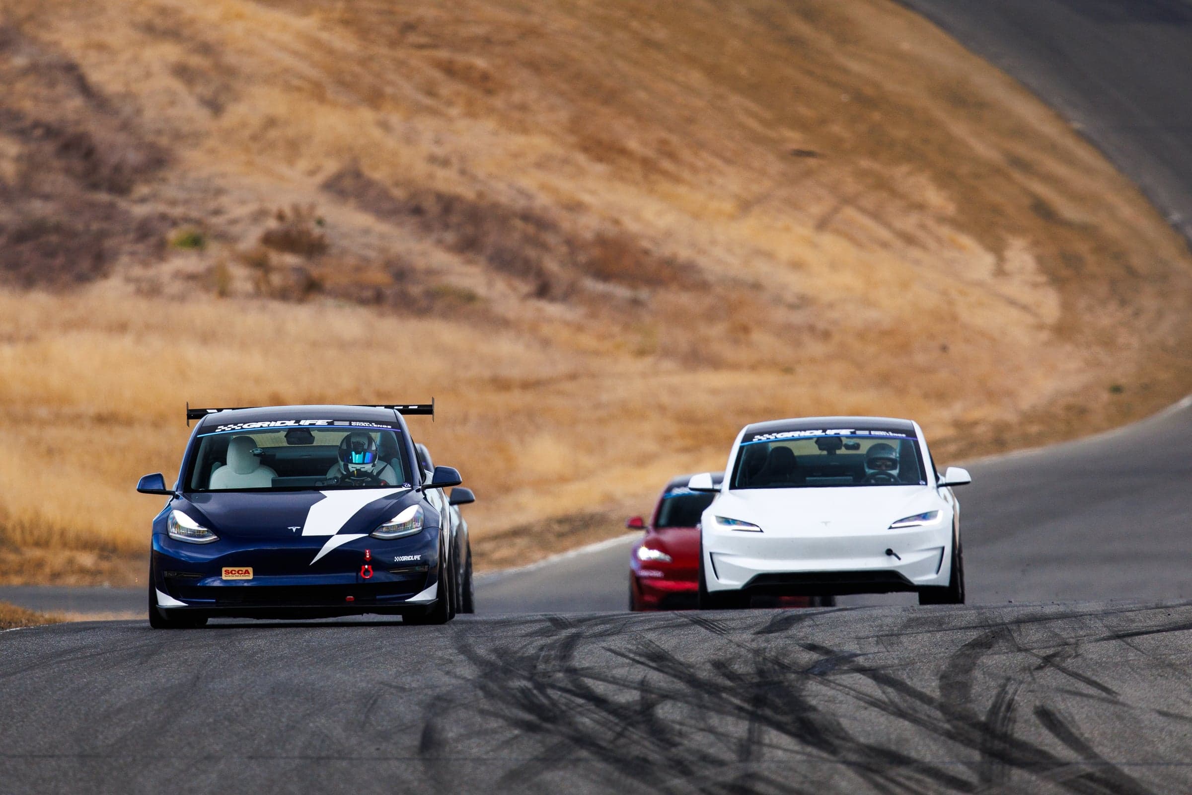 Model 3 Performance cresting a hill head-on among other cars