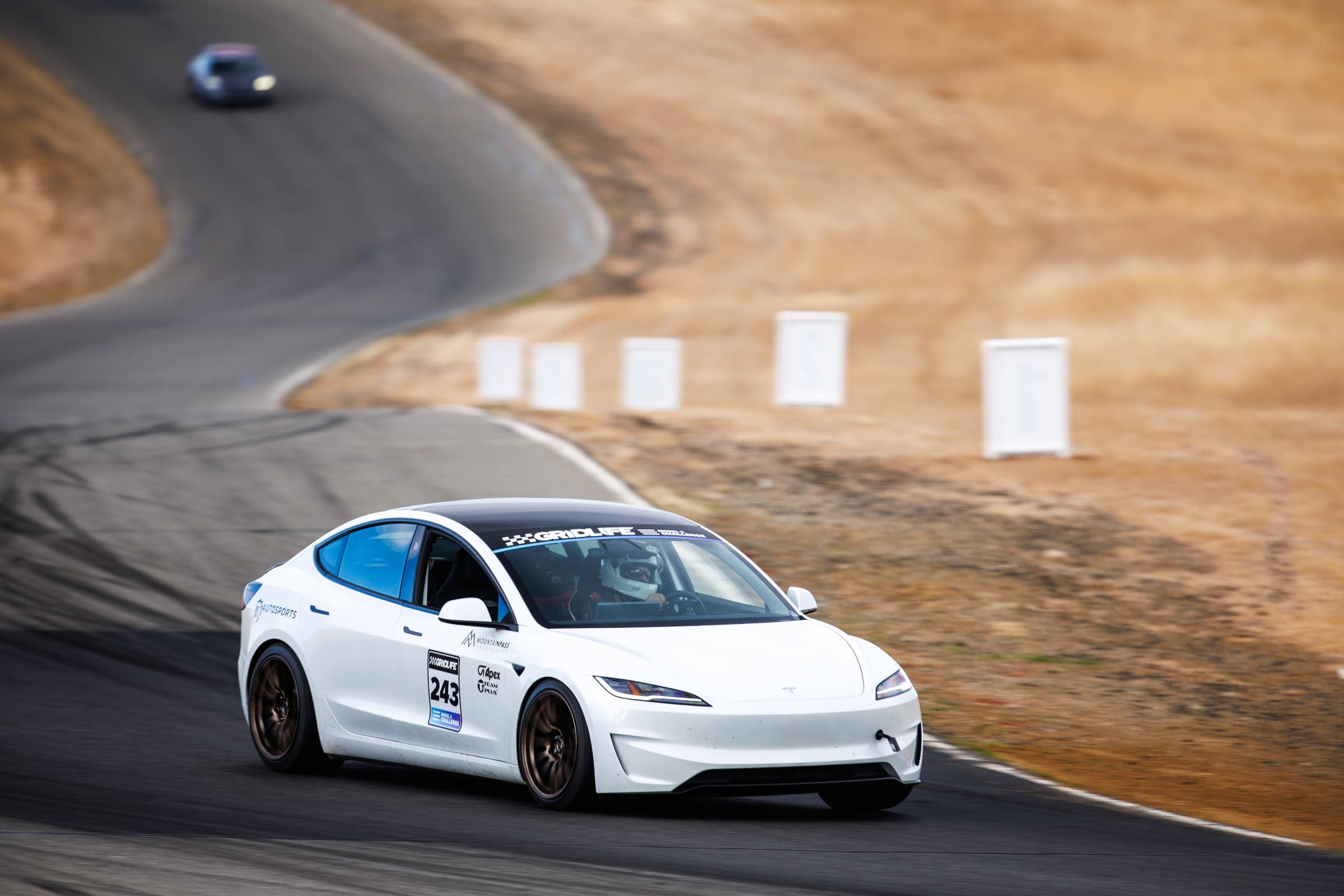 Model 3 Performance mid-corner with the driver visible at the wheel